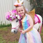 Girl In Rainbow Dress Hugging Pony 